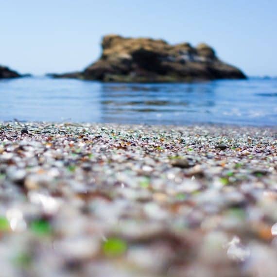 sea glass on a beach with ocean behind