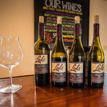 four bottles of Lula Cellars wine on a bar