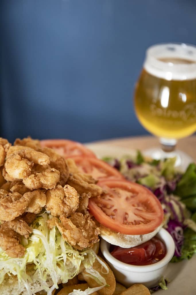 a dish with fried shrimp and a beer