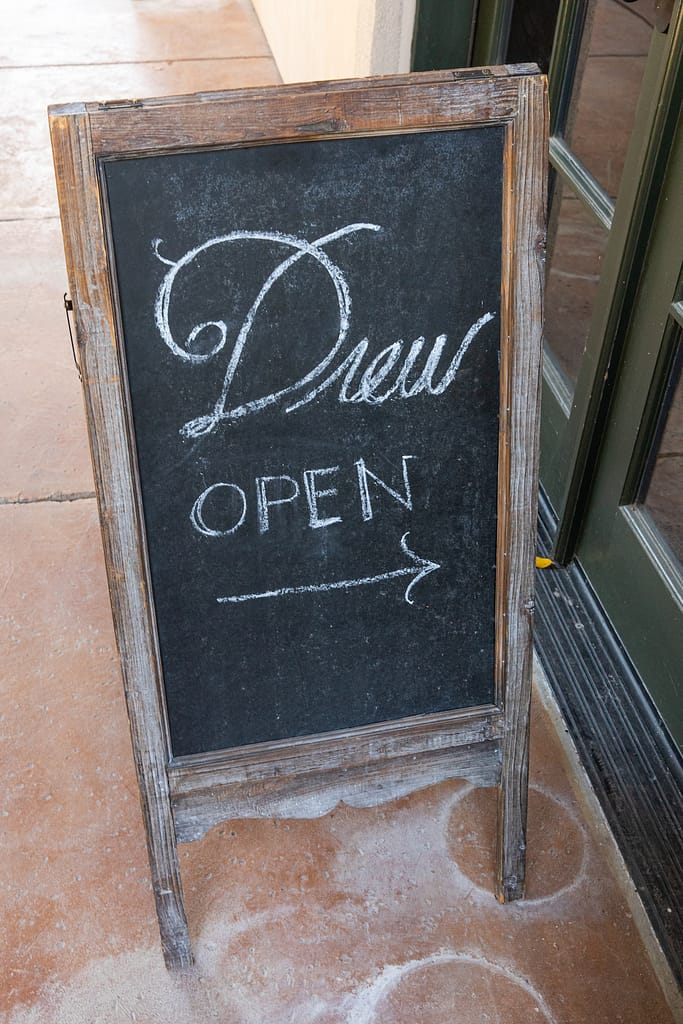 a chalkboard open sign for Drew