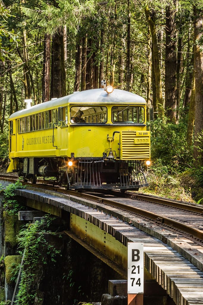 a yellow train engine crossing a bridge