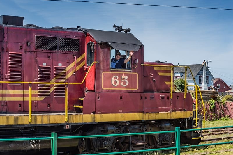 a conductor waving from a red train