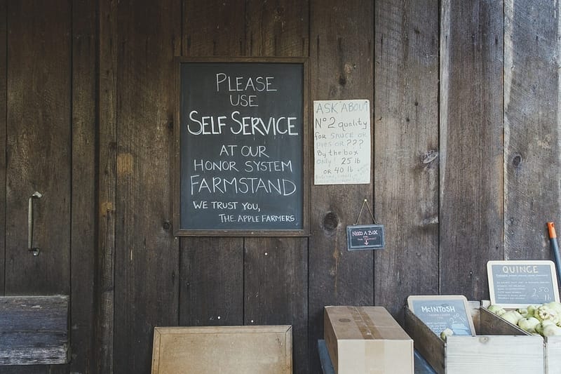a Self Service sign of the side of a wooden barn